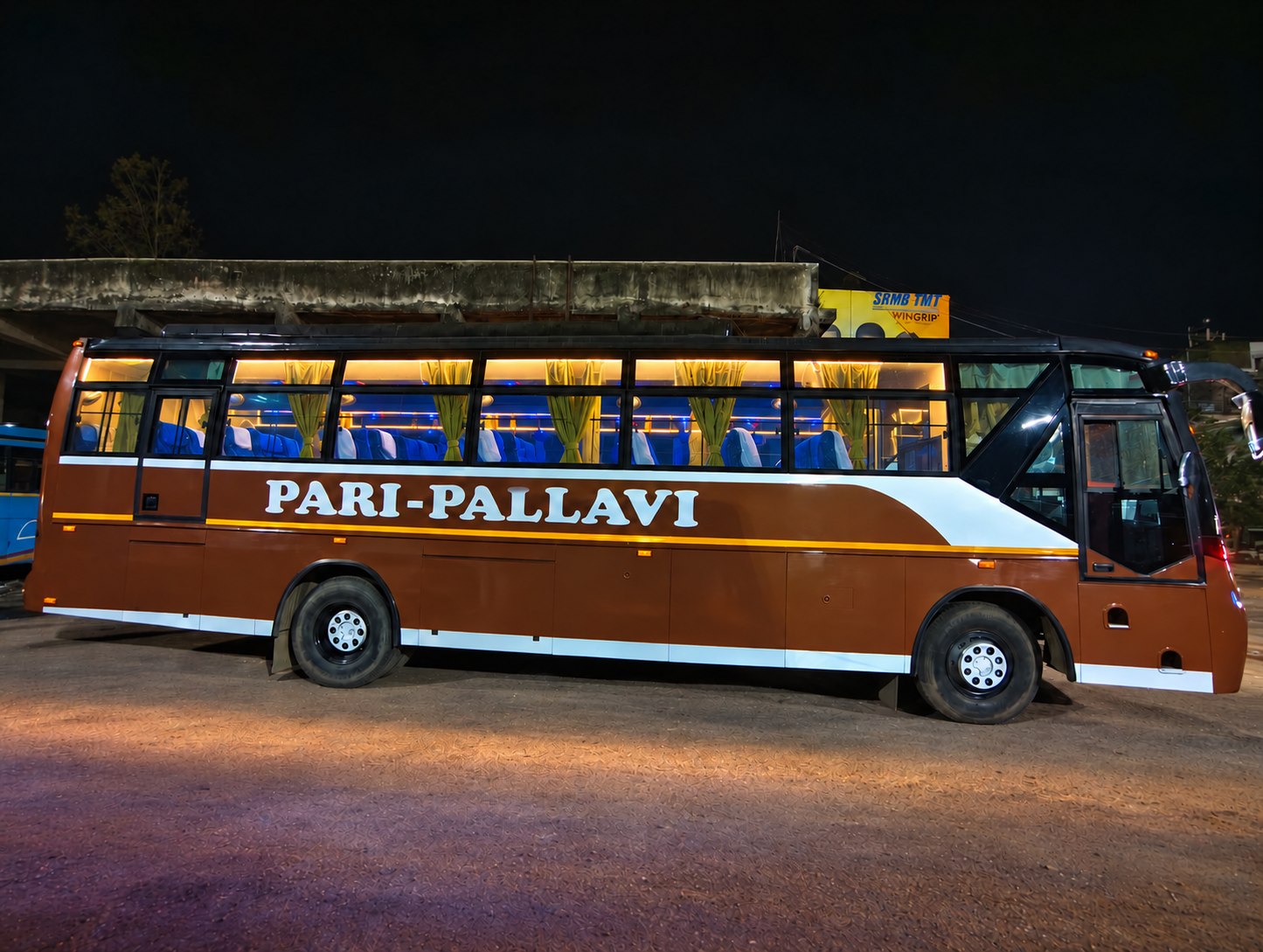 Pari Pallavi bus at night, side view with the ground cleaned